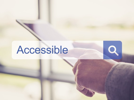 Image of a Search box with the word "Accessible" typed in, with hands holding a tablet in the background 